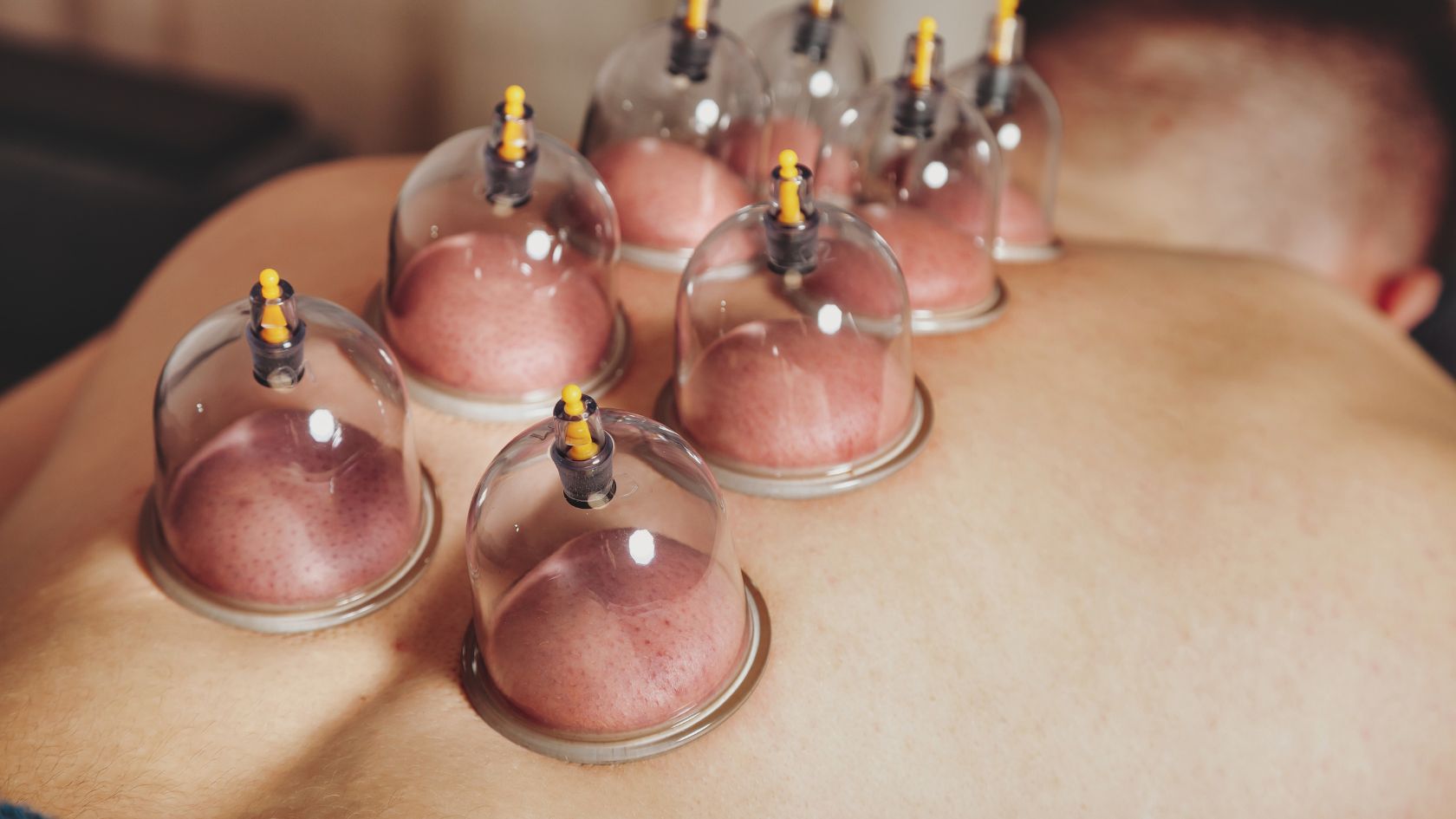 A man laying down with a bunch of bottles on his back