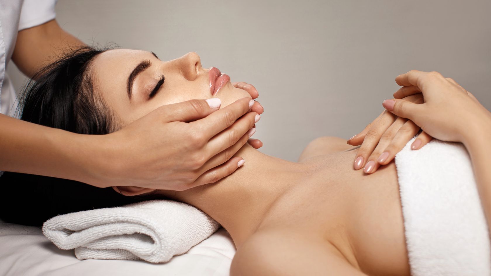 A woman getting a facial massage on her face