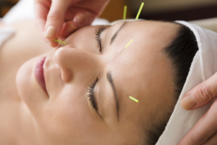 A woman getting a facial massage at a spa